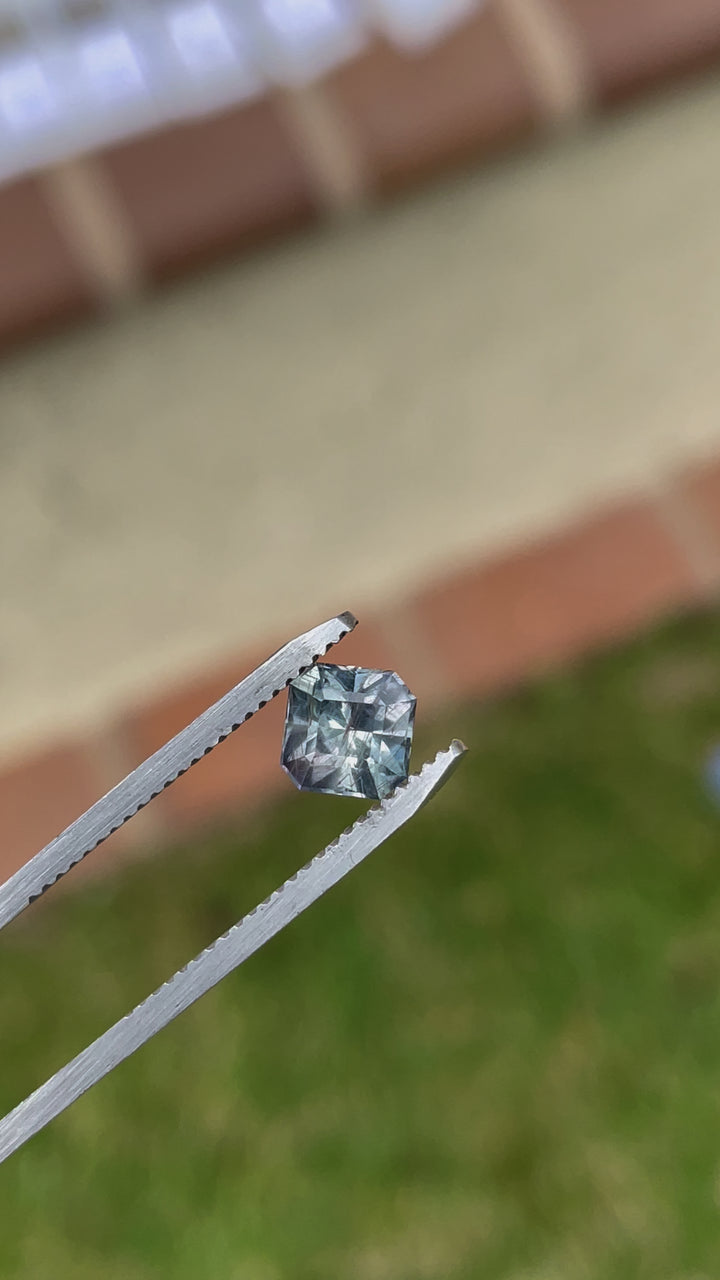 Video capturing the unique beauty and geometric precision of a modified Asscher cut sapphire from Tanzania, displayed in natural lighting to enhance its color depth.