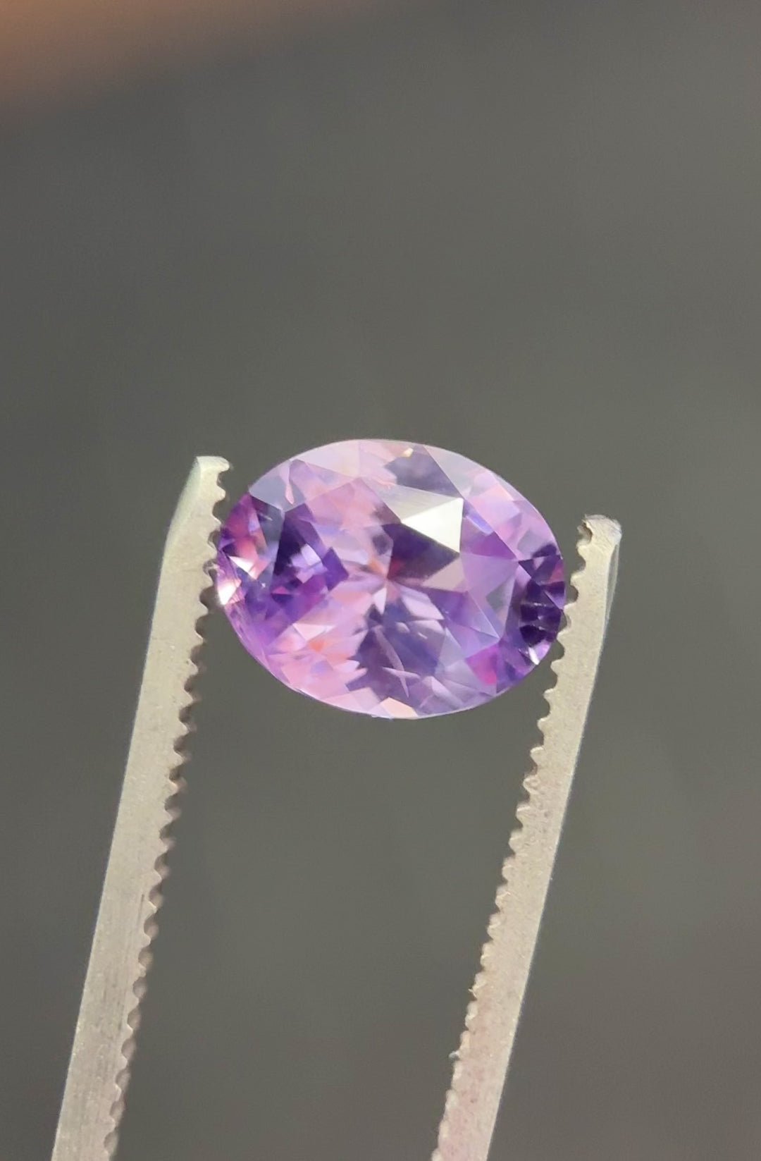 Video of 4.04 carat sapphire from Sakaraha, Madagascar rotating under natural light to show pink, violet, and purple hues in a precision oval cut.