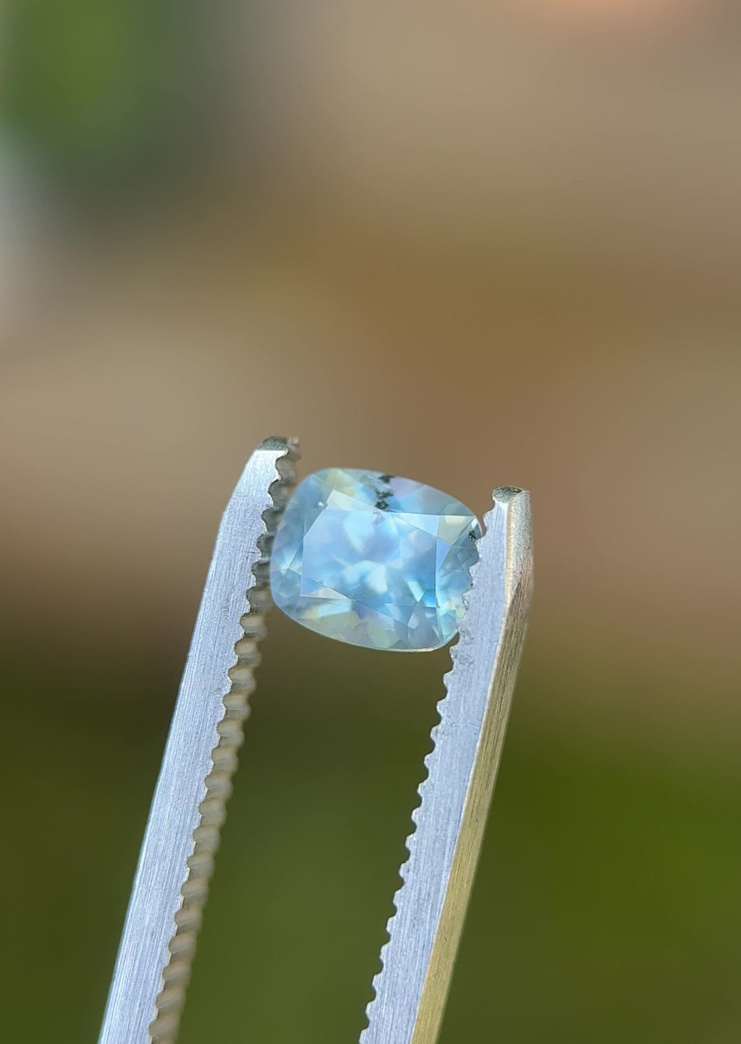 360-degree video of untreated 1.22ct periwinkle blue Montana sapphire in elongated cushion cut, shown in natural lighting with tweezers