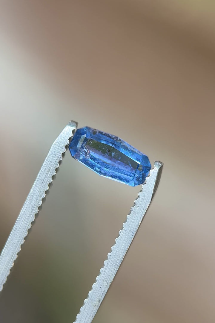 Rotating view of 1.05 carat cornflower blue sapphire with custom elongated cushion step cut – Umba River origin, shown under natural light