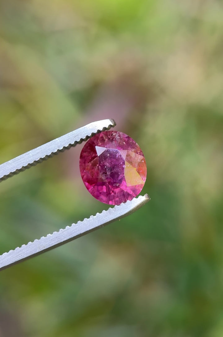 360-degree video of untreated purplish red Tanzanian sapphire in oval cut, showcasing natural light reflection and internal features