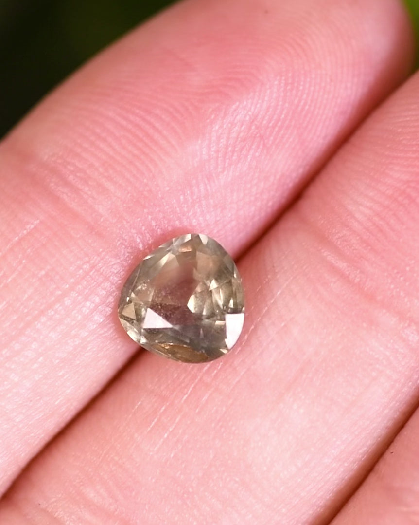 Macro video of 1.94 carat teal green yellow sapphire turning slowly, capturing its internal brilliance, fine portrait pear cut details, and natural unheated clarity from Umba River, Tanzania.