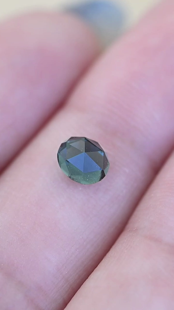1.06ct teal blue green oval double rose cut sapphire shown in hand under natural light
