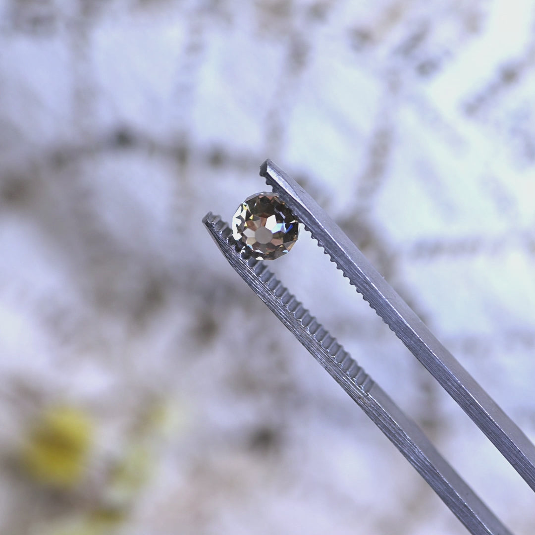 Loose fancy yellow brown Mughal cut diamond from South Africa rotating in tweezers, showcasing its symmetry, sparkle, and antique-inspired cut.