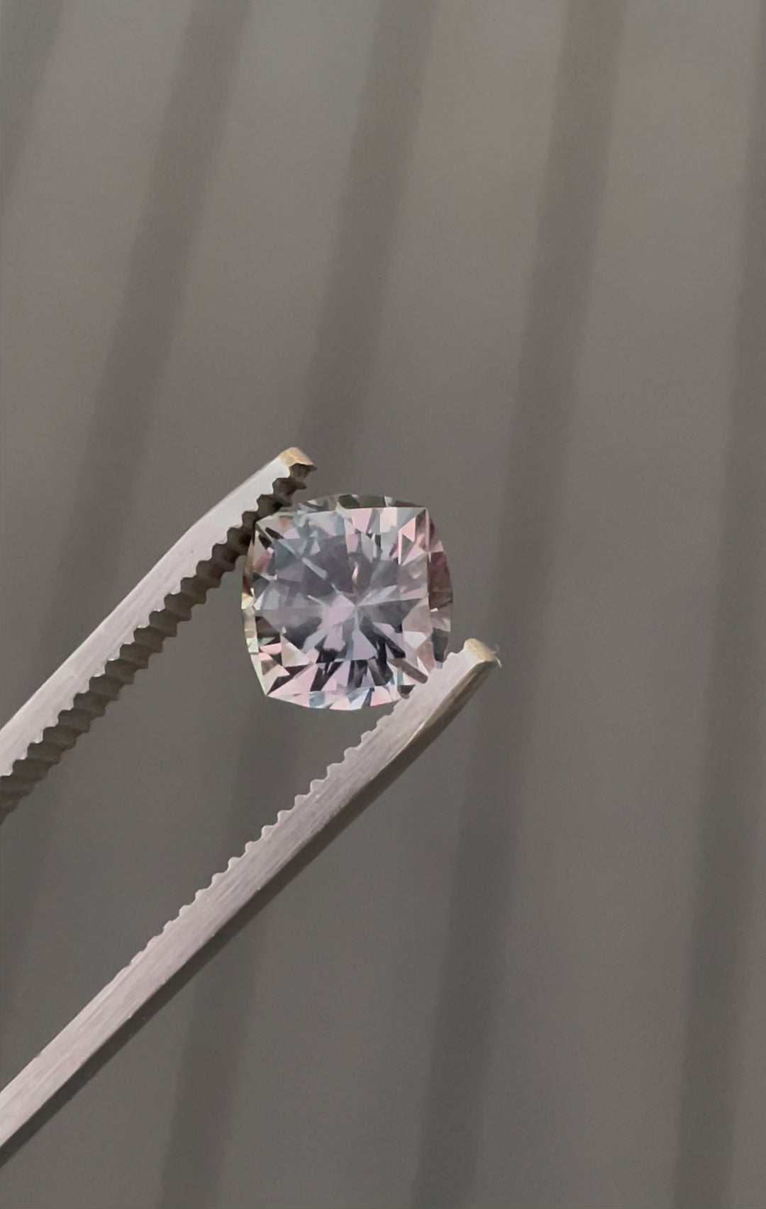 Video showing the color transformation of a 3.13-carat sapphire under incandescent lighting, highlighting its pinkish-purple tones.