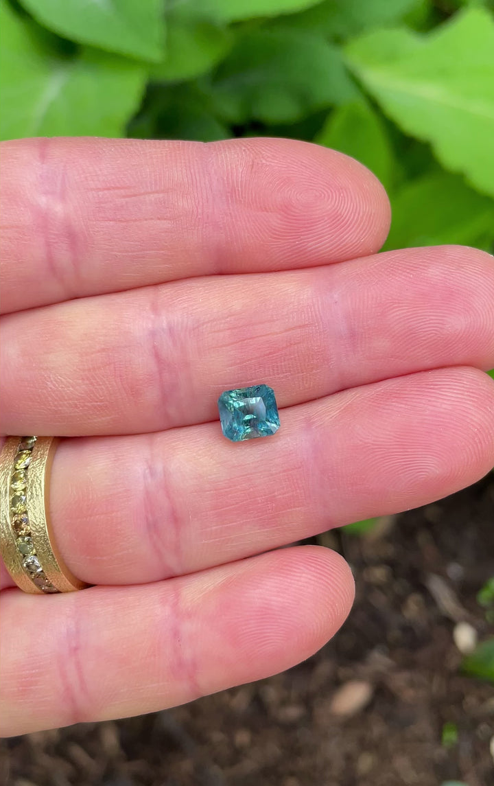 Video of a 2.50-carat Asscher cut sapphire from Montana showing teal, blue, and green color shifts in natural sunlight.
