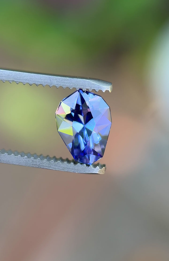 Close-up video of untreated Ultra Violet Blue Tanzanite in tweezers, spinning to reveal exceptional clarity and fire.