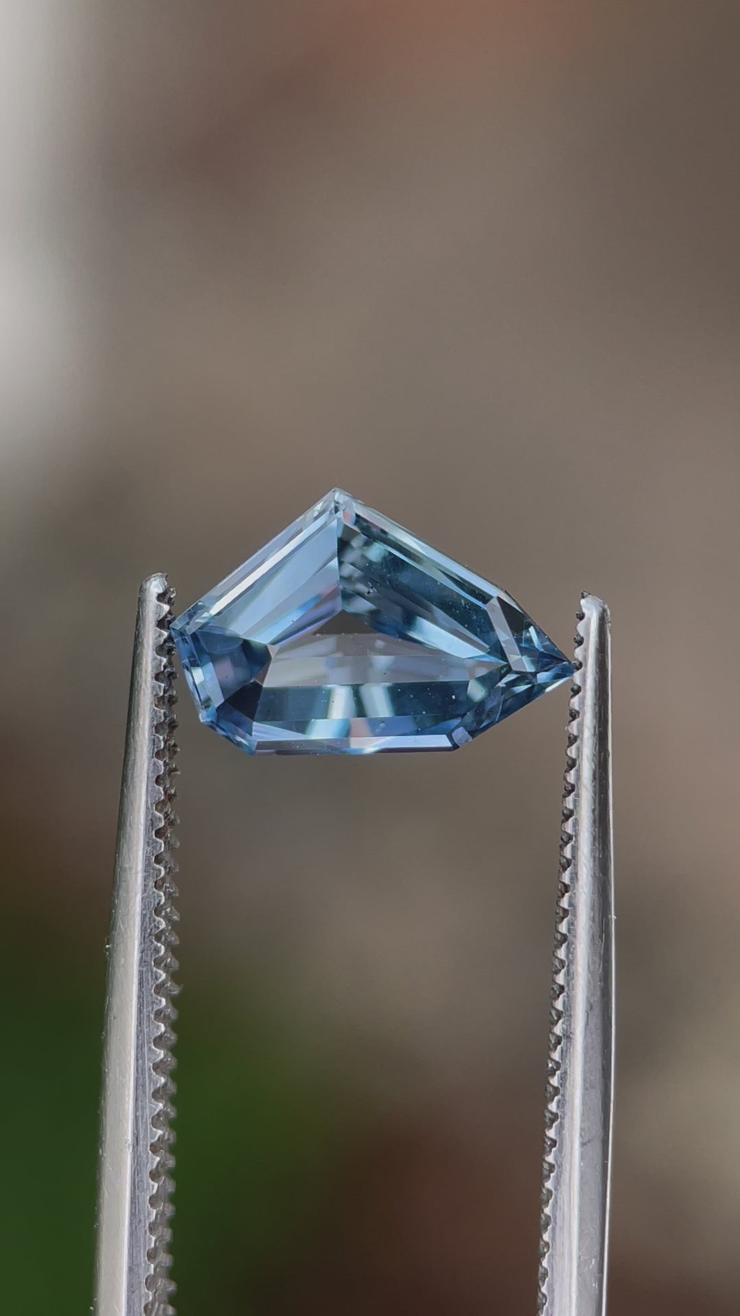 360-degree video of a 2.23-carat blue sapphire in a free-form geometric cut, displaying its sparkle and vibrant blue hues under natural light. Origin: Sri Lanka, Untreated.
