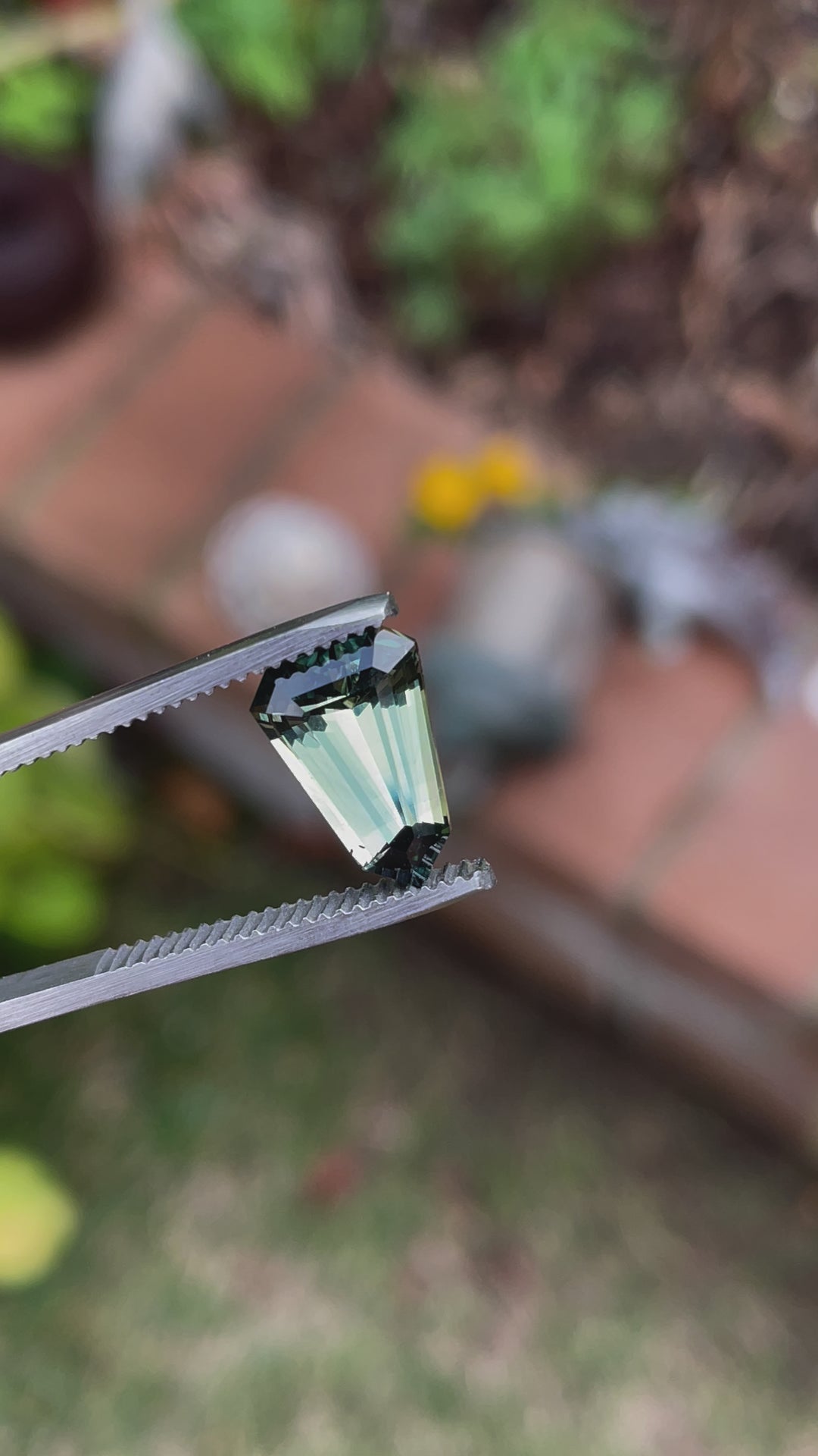 Rotating video of a 4.07 carat shield cut sapphire, highlighting its vivid teal, blue, and green coloration and Madagascar origin under natural light.