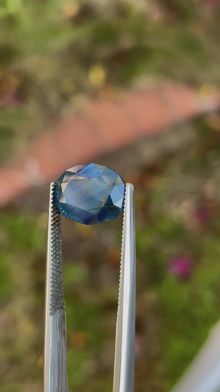 Video showcasing a 5.23 carat sapphire with hues of blueberry, green, and teal, oval cut, from Gombe, Nigeria.