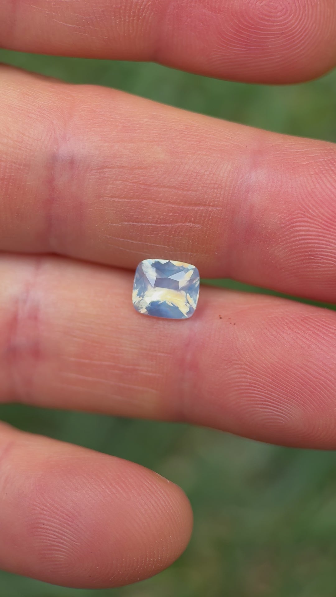 Macro close-up video of 2.00CT sapphire from Ratnapura, Sri Lanka, showing brilliance and silky opalescent luster in its squared cushion cut as it moves through sunlight.