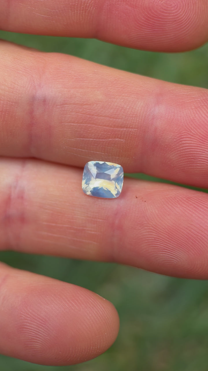 Macro close-up video of 2.00CT sapphire from Ratnapura, Sri Lanka, showing brilliance and silky opalescent luster in its squared cushion cut as it moves through sunlight.
