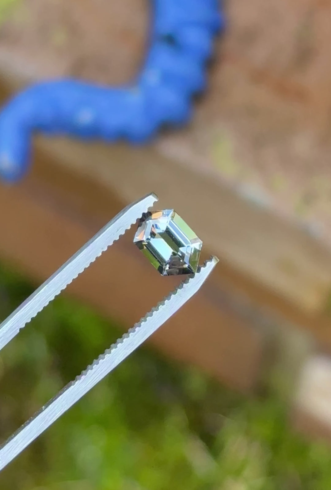 360-degree view of 1.14 carat Tanzanite gemstone on hand, capturing its mermaid color shift and step hexagon cut in natural lighting