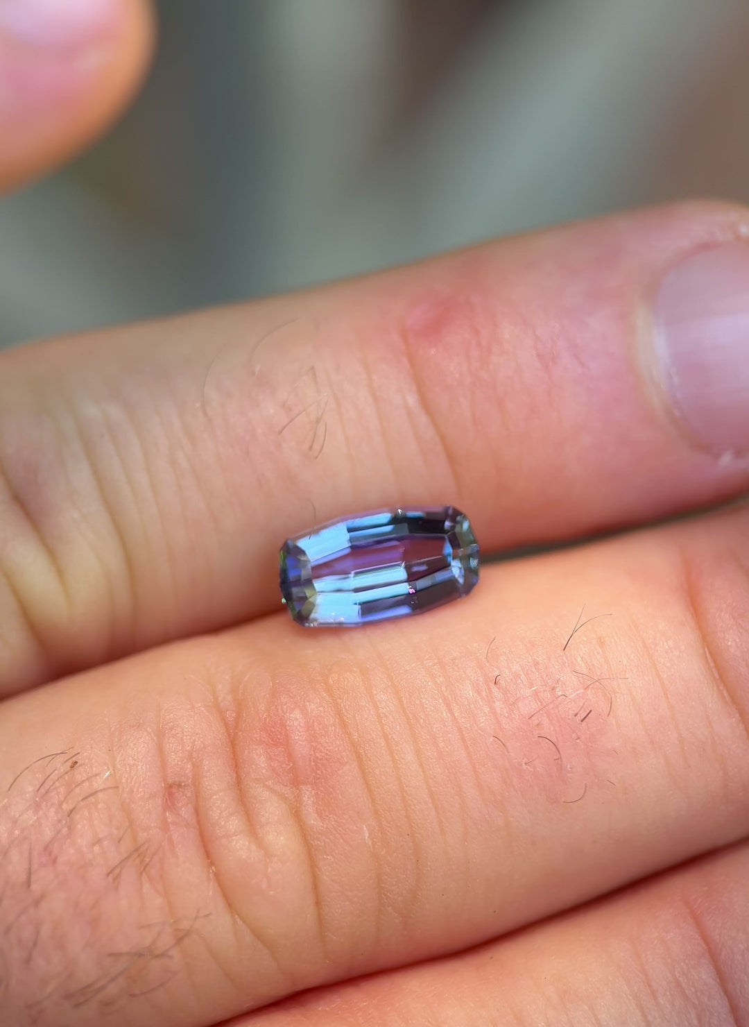 Handheld video of untreated Tanzanite showing natural color transitions of green, yellow, and violet under sunlight