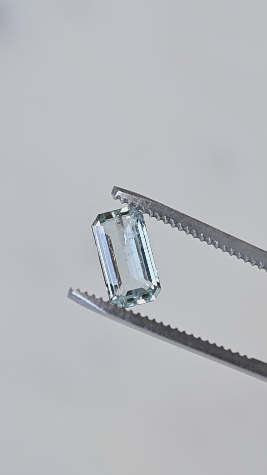 A close-up rotation of this natural Colorado aquamarine highlighting its elongated octagonal step cut, refined geometry, and clean, transparent crystal.