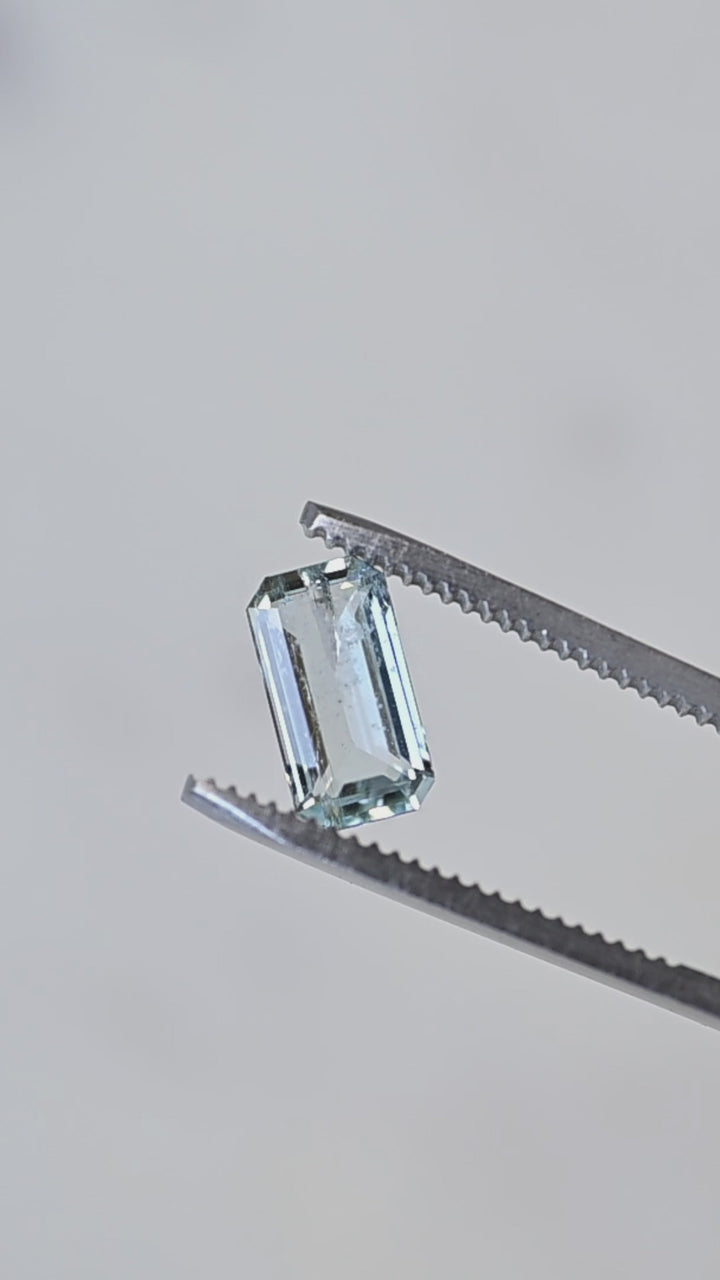 A close-up rotation of this natural Colorado aquamarine highlighting its elongated octagonal step cut, refined geometry, and clean, transparent crystal.