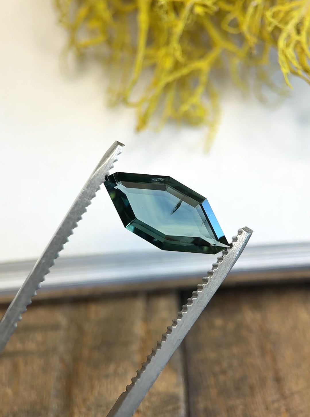 Rotating video of freeform geometric sapphire from Nigeria showing color play between teal and deep blue.