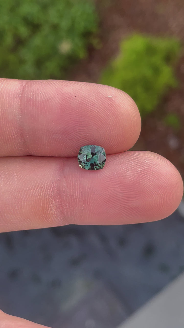 A close-up video of a 1.55-carat sapphire with blue and green hues, originating from Madagascar. The stone is rotated to reveal its fancy mixed cut and natural untreated beauty, emphasizing the depth and brilliance of its colors.