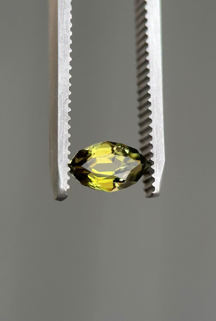 Video of a 0.94-carat olive green tanzanite being rotated under bright light to show the custom antique style cut, natural color, and brilliance. Untreated Tanzanite from Merelani Hills displaying clarity and faceting detail.