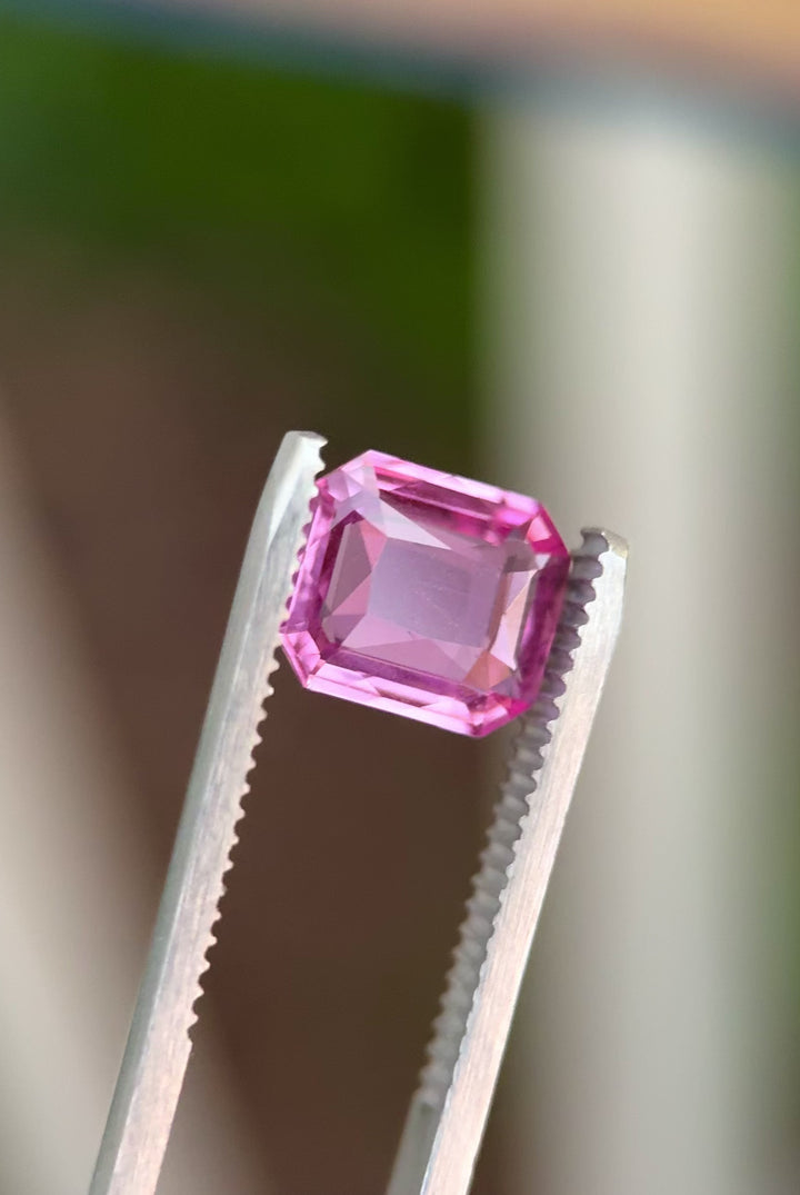 Video of 3.01CT pink sapphire rotating in gemstone tweezers, displaying its radiant brilliance and crisp step faceting of the custom octagonal portrait cut, unheated sapphire from Sakaraha, Madagascar.