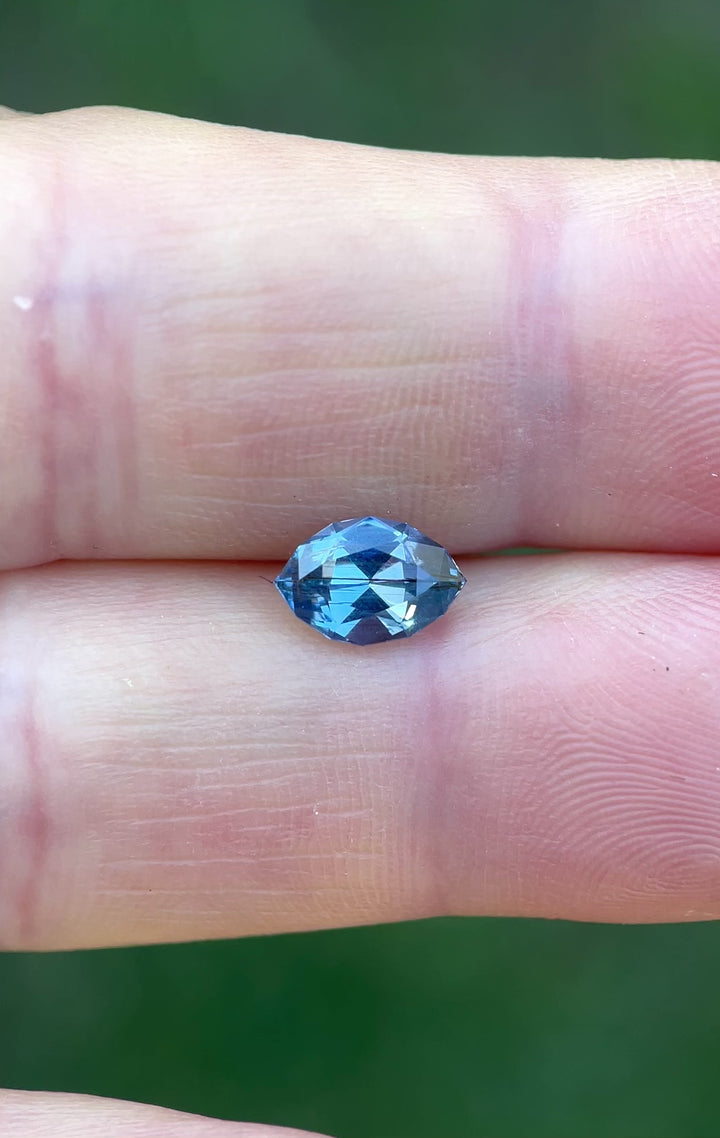 Handheld video of a 1.36ct marquise-cut sapphire from Umba River, showing flashes of blue and periwinkle as the stone moves in sunlight.