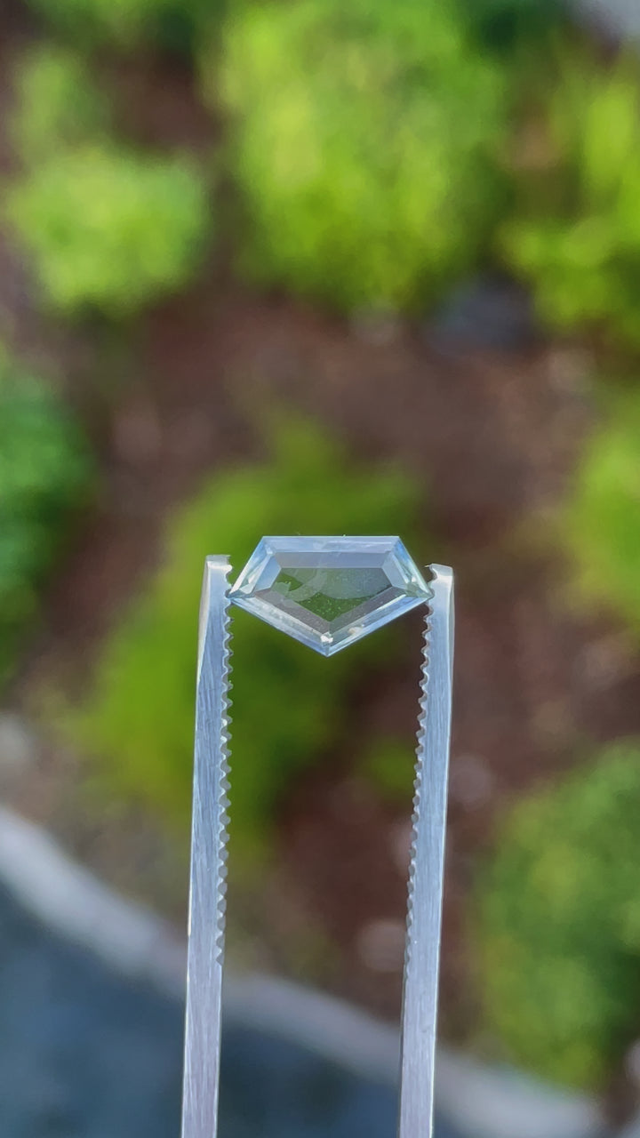 Video showcasing the unique color transitions of a geometric step cut sapphire gemstone, weighing 1.20 carats and hailing from Sri Lanka, demonstrating its clarity and sparkle under different lighting conditions.