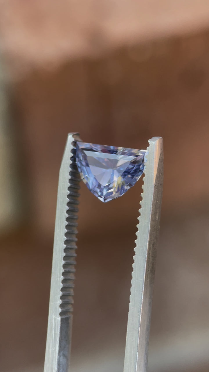 Rotating view of a 1.66ct Sri Lanka sapphire, capturing its shifting periwinkle and pink tones under natural light.