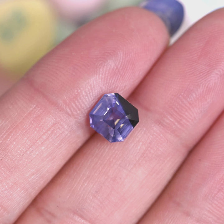 Rotating loose lavender and periwinkle blue sapphire precision Asscher cut from Sri Lanka revealing step facets and soft color shift as the stone turns in light.
