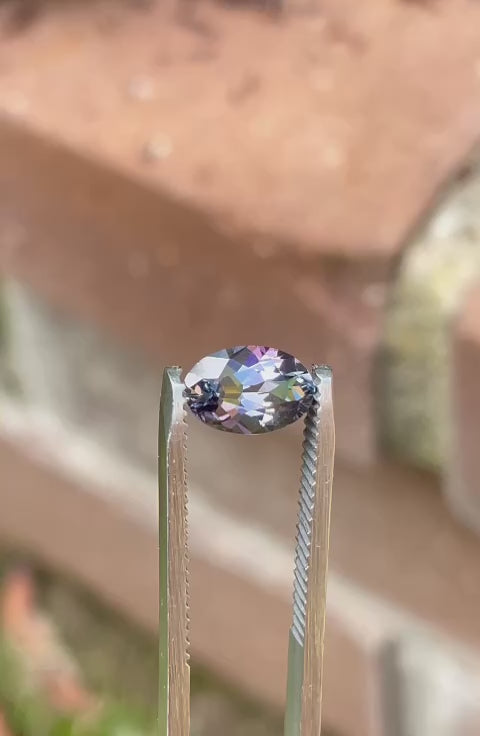 Video displaying the captivating beauty of a 1.50 carat Tanzanite gemstone from Tanzania, rotating to show its mix of green, teal, and purple colors and custom mix cut oval shape. The video captures the gemstone's natural allure and detailed facets.