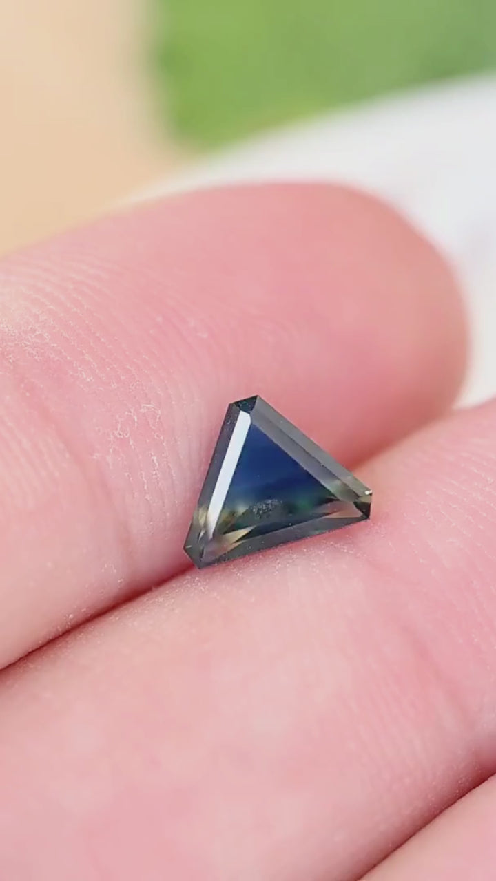 Explore the scale and contrasting blue, yellow and green color zones of this untreated 1.28ct Madagascar sapphire in a precision trillion cut.