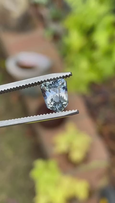 Video of a 2.74-carat custom step cut shield Sri Lankan sapphire, showcasing its exceptional clarity and multi-colored hues, rotating to display all angles.