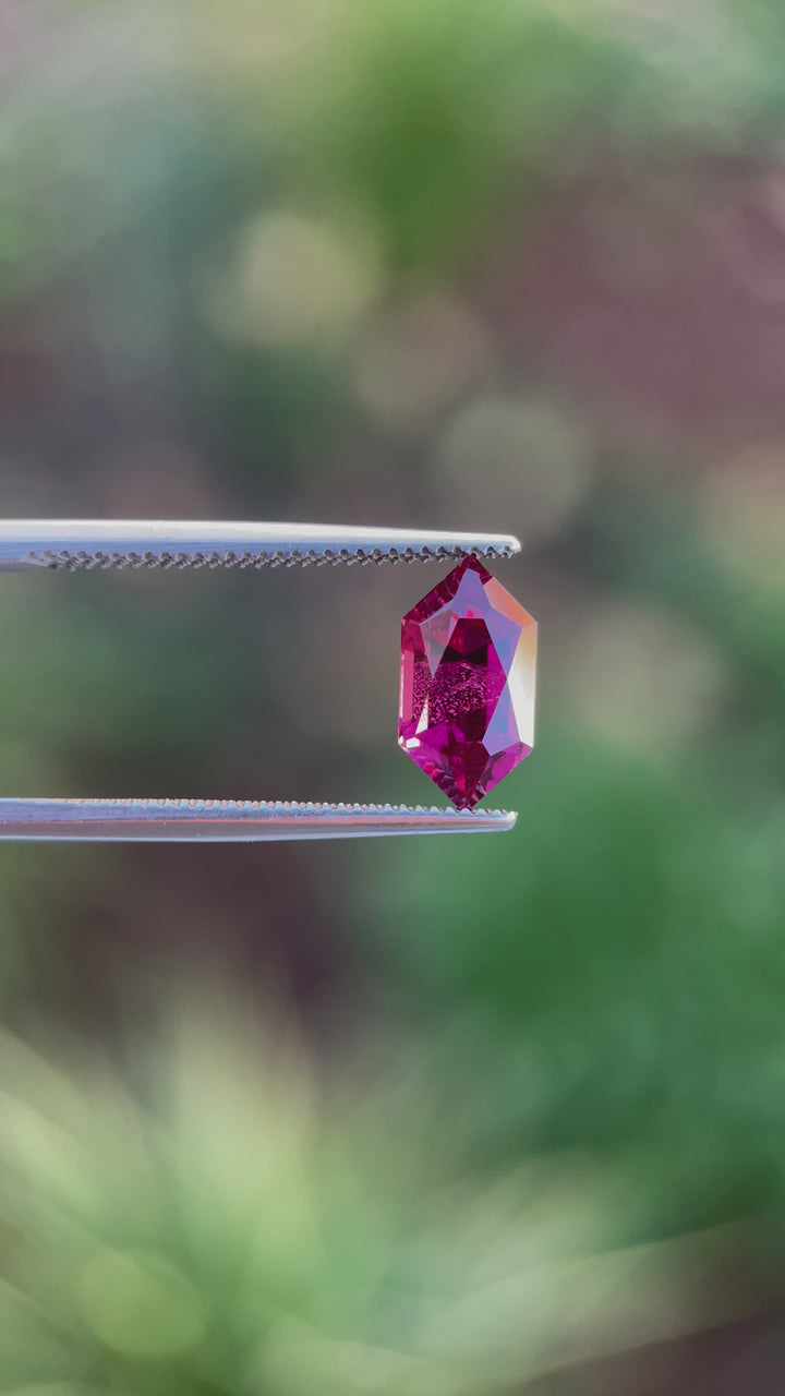 360-degree video of a 2.40 carat red-purple garnet gemstone from Kenya, highlighting its geometric hexagon cut and natural untreated beauty.