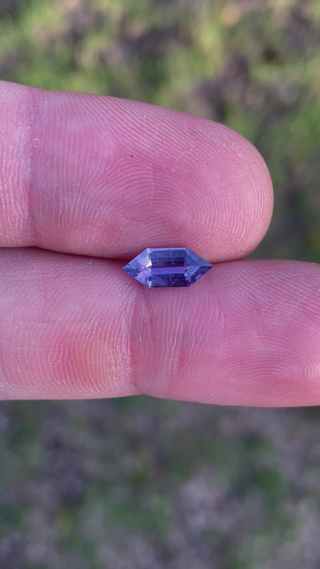 Close-up video of a natural 1.01-carat Madagascar sapphire, showcasing its stunning step-cut hexagonal shape and rich purple-pink hues.