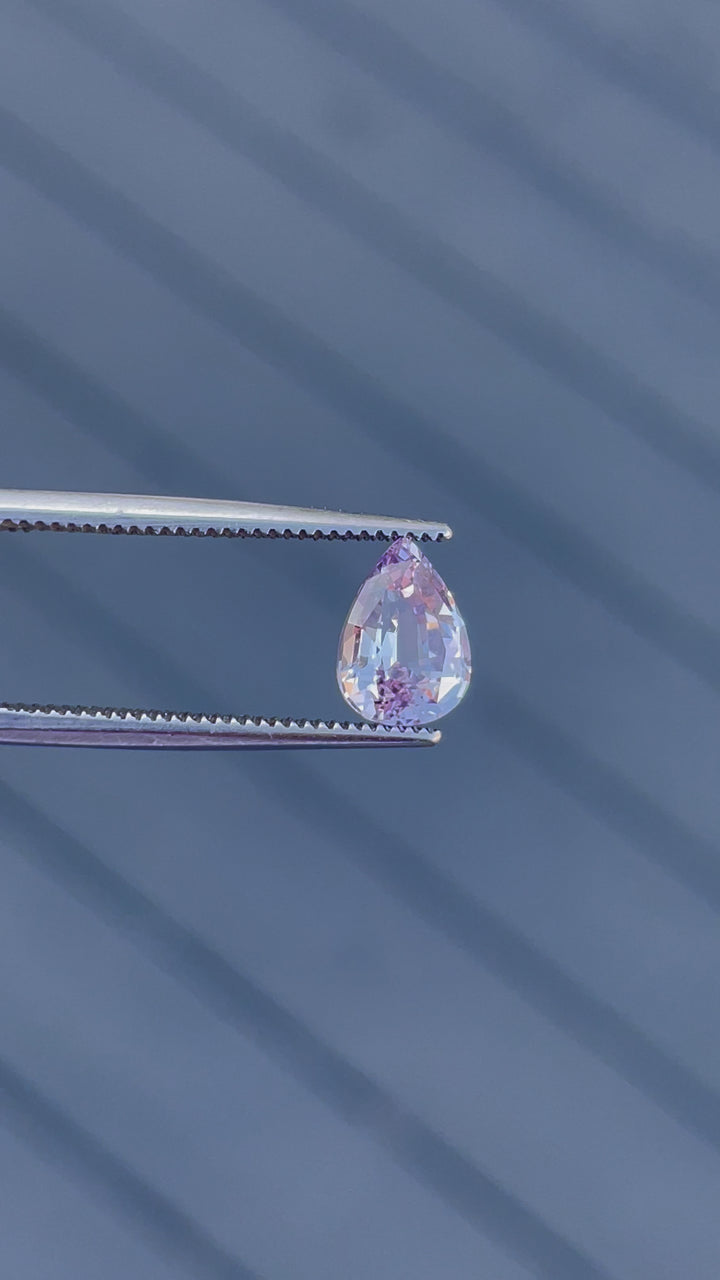 A 360-degree view of a 1.68-carat pastel purple and pink sapphire in a pear cut, reflecting brilliant sparkles. An untreated gemstone from Sri Lanka.