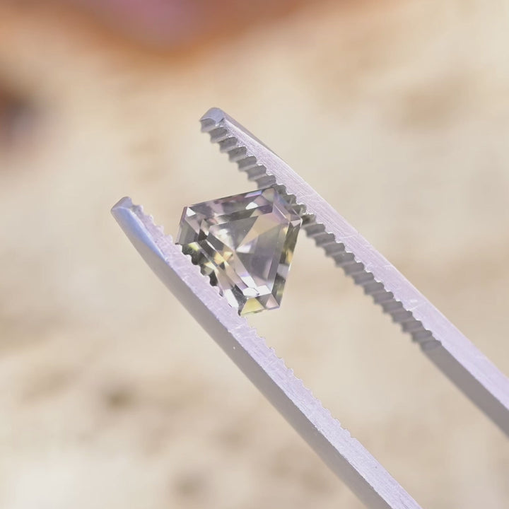 Close up video of 1.87ct peach lavender Tanzanite displaying custom step cut faceting brilliance and natural gemstone clarity