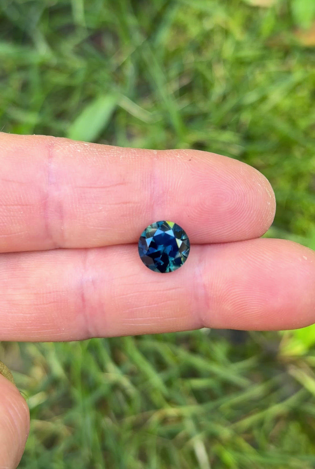 Natural light video of a 3.98 carat peacock teal blue green sapphire, round brilliant cut from Gombe Nigeria, highlighting untreated clarity, depth, and sparkle