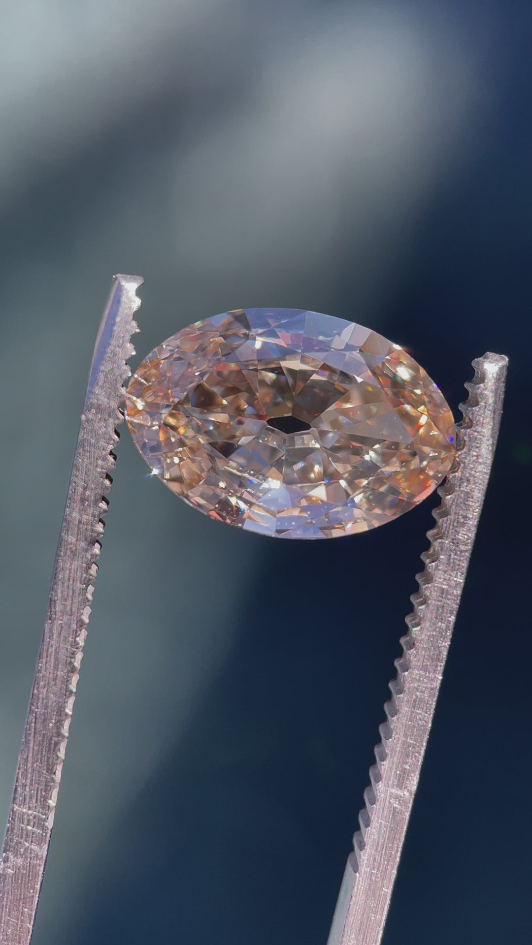 A high-resolution video of a 3.01-carat moval cut diamond with fancy light brown champagne color, captured under different lighting to showcase its brilliance and fire.