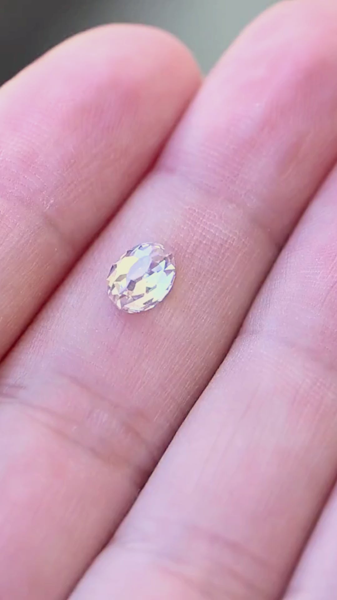 1.08 carat oval Mughal cut South African diamond shown moving on a hand, revealing its scale and softly shifting white, champagne and cool-toned reflections.
