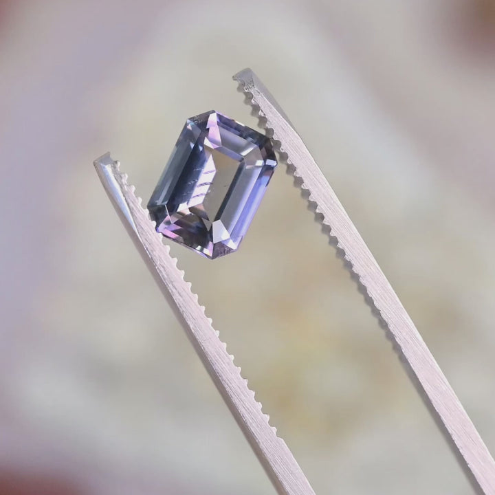 1.76 carat modified emerald cut Tanzanite rotating under light showing blue and purple color shift natural untreated brilliance from Tanzania