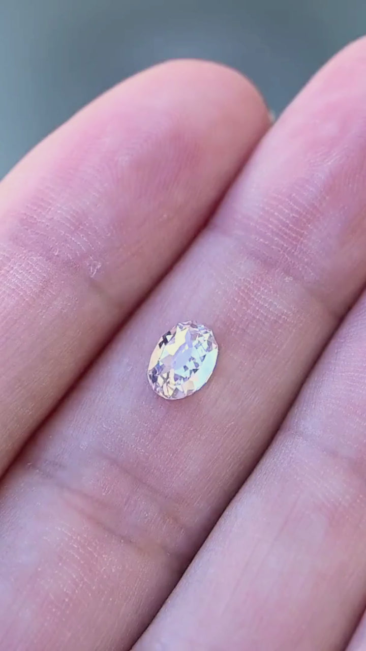 1.11 carat oval Mughal cut diamond shown in motion on a hand, revealing its scale and shifting white, pale blue and softly warm reflections.