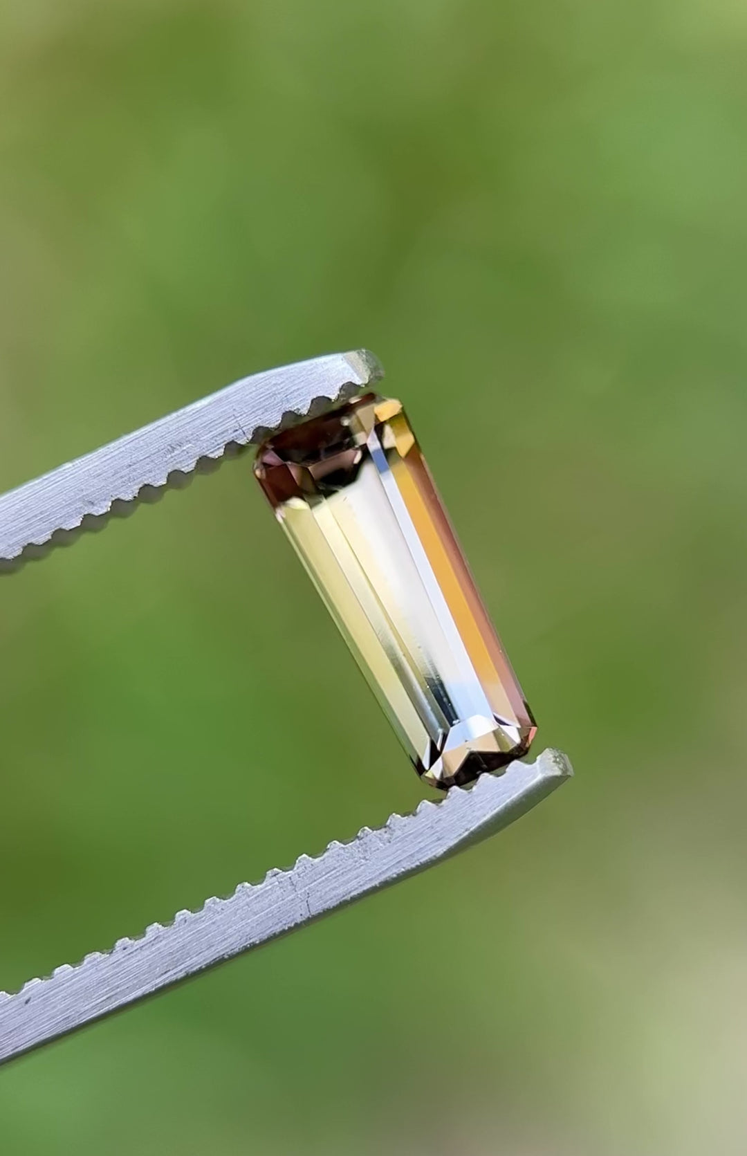 Rotating video of a 1.26CT Tanzanite showing golden yellow and lavender reflections in elongated emerald cut.