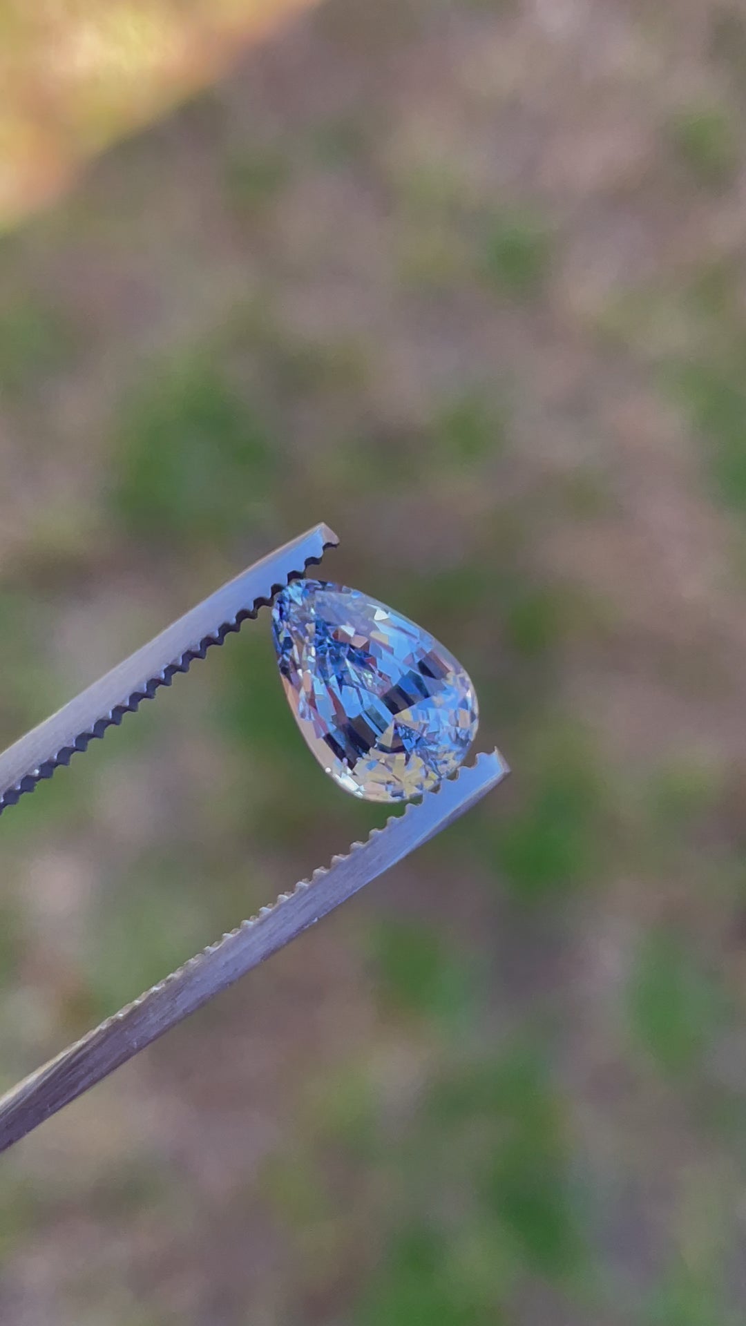 A detailed video showcasing a cornflower blue and powder blue sapphire weighing 2.39 carats. The custom tear-drop-shaped gemstone features brilliant cut facets and is untreated, originating from Sri Lanka.