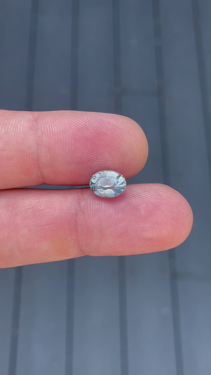 Dynamic showcase of a 3.19 carat teal and seafoam sapphire, mix brilliant oval cut, highlighting its color change effect under different lighting conditions, sourced from Sri Lanka.