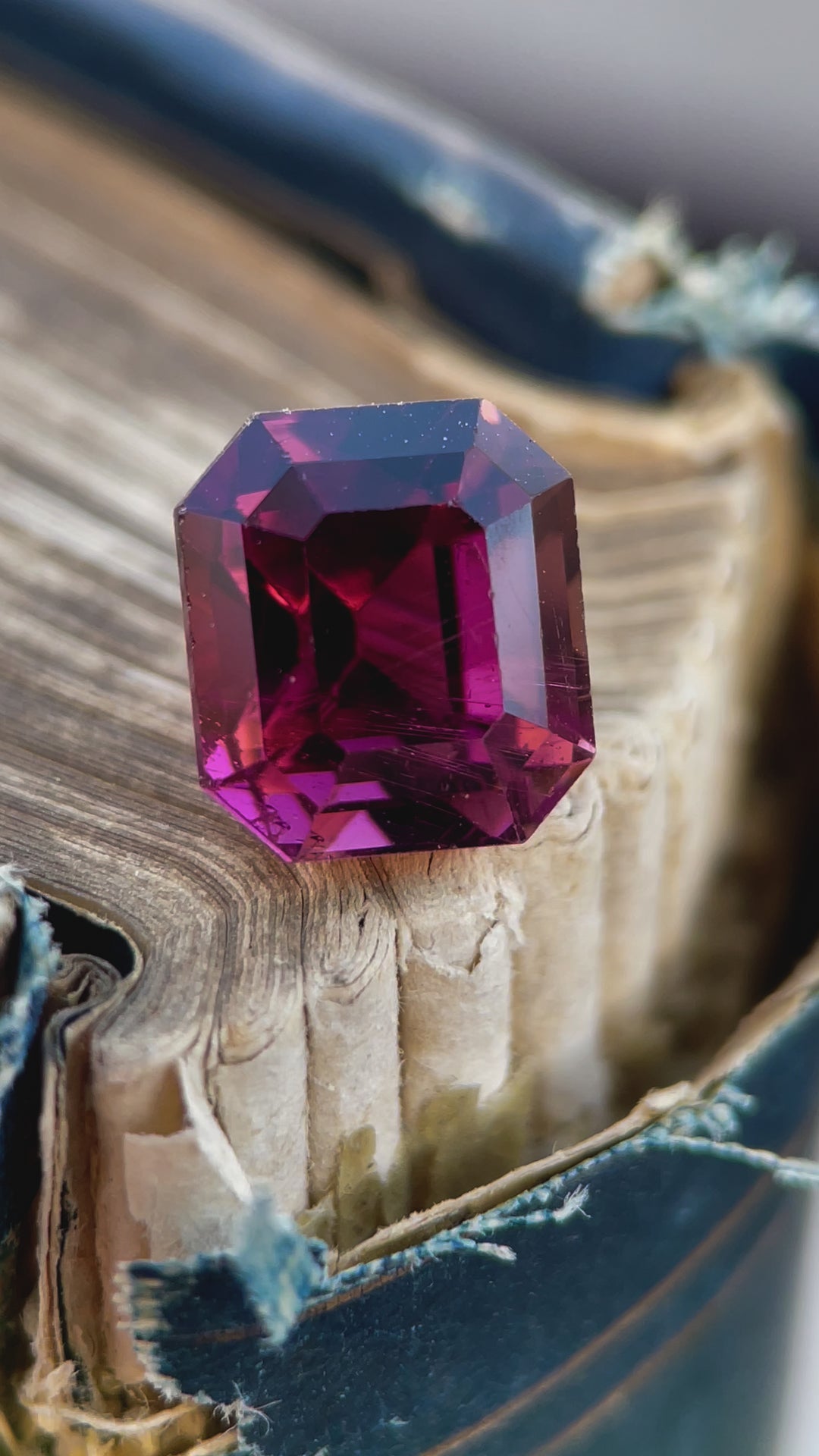 A detailed view of a 4.65-carat emerald-cut tourmaline, emphasizing its unique play of red, purple, and pink tones.