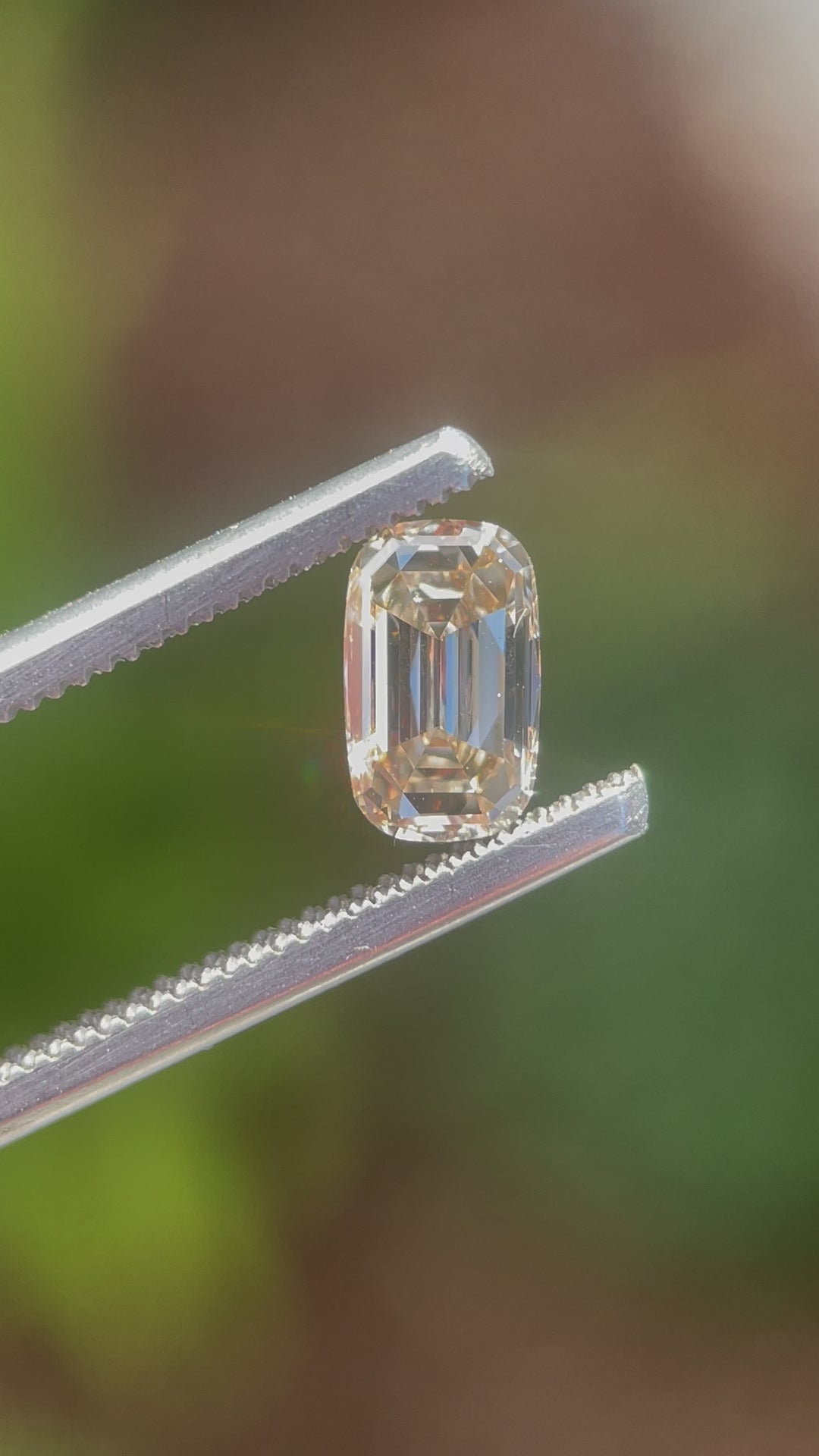 A natural light video displaying the 1.03-carat diamond’s brilliance, clarity, and elegant elongated step cut cushion shape with a warm champagne tone.