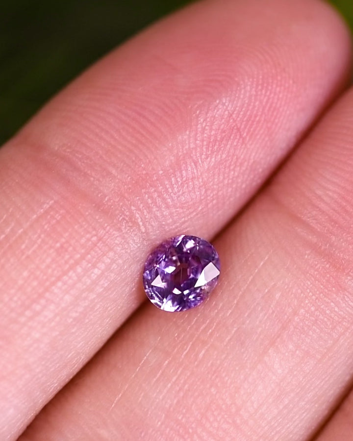 Close-up video of 0.68 carat violet purple sapphire rotating under natural light, displaying the brilliance and depth of its modified oval cut, ethically sourced and unheated from Umba River Valley, Tanzania.