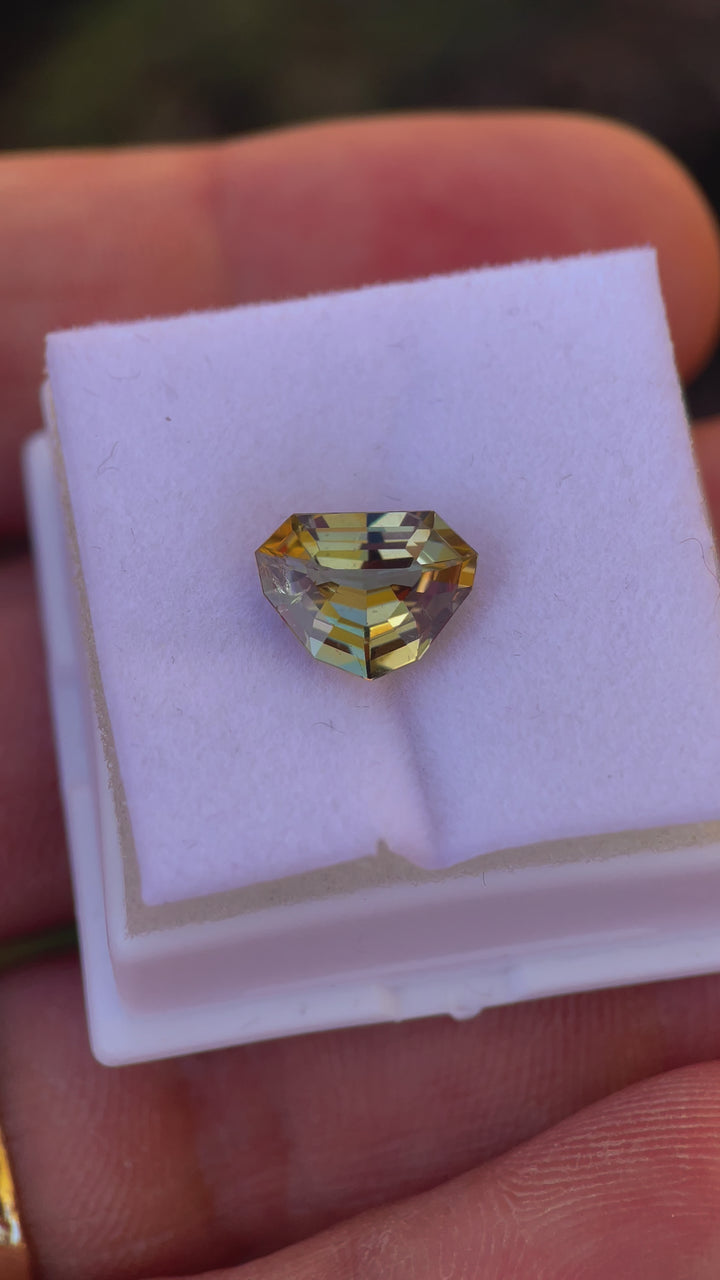 Video displaying the captivating colors and brilliance of a 2.99 carat Tanzanite with a custom shield step cut, showing shades of slightly teal, peach, and yellow, sourced from Merelani Hills, Tanzania.