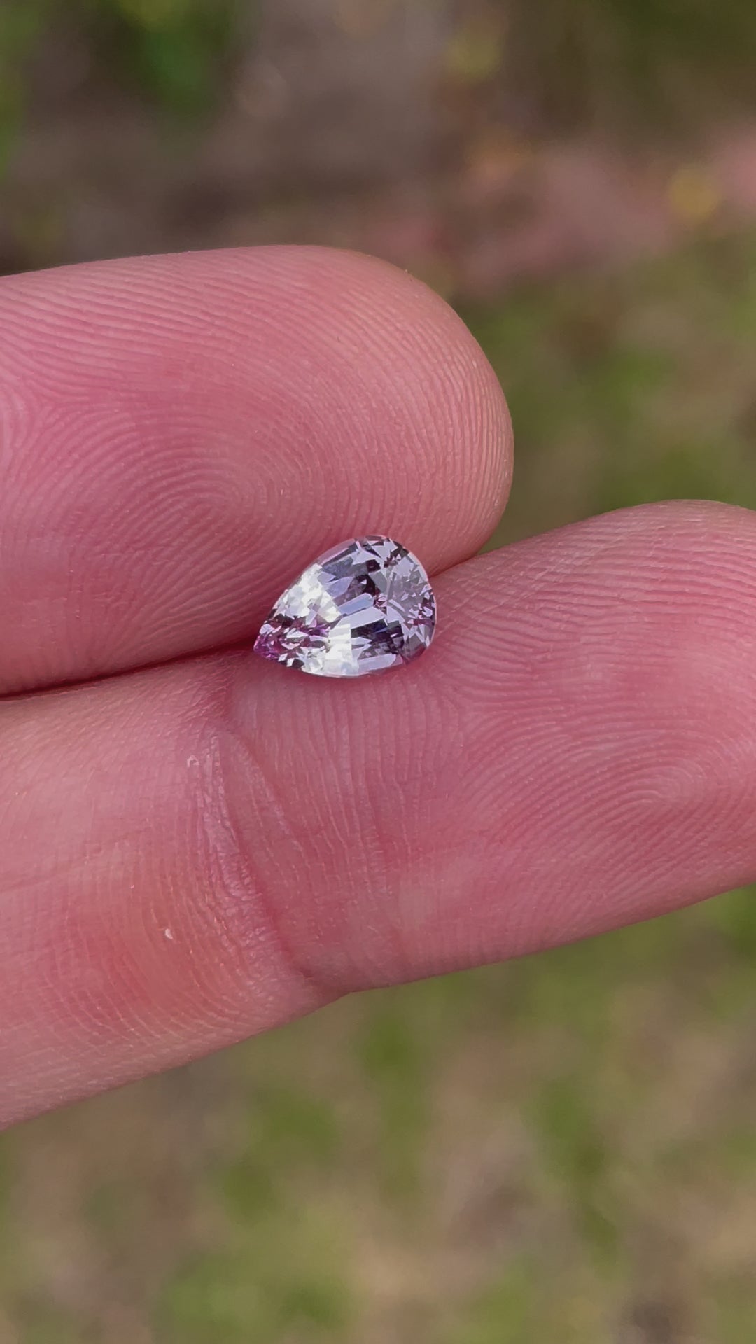 A 360-degree video showcasing the brilliance of a 1.68-carat sapphire with pastel purple and pink hues. The gemstone features a mix modified brilliant pear cut, untreated and ethically sourced from Sri Lanka.