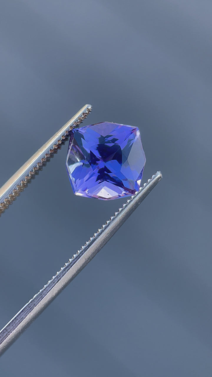 Detailed video of a 3.27-carat Tanzanite with a custom geometric cushion cut, exhibiting vibrant purple and ultra violet hues. Untreated gemstone from Merelani Hills, Tanzania.