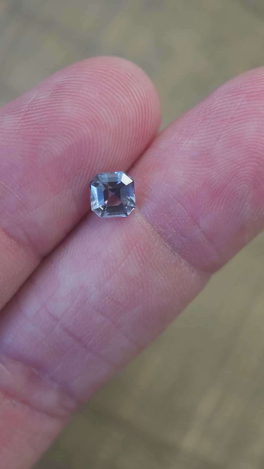 Video showcasing a 1.10 carat Tanzanite gemstone in Asscher cut, highlighting its teal, blue-green, and purple colors under varying light angles for a dazzling display.